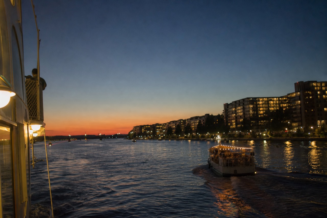 Savannah riverboat on the water at dusk with the riverfront in the background, no text, no logos, no people