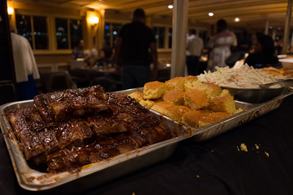 Rack of ribs, cornbread, and coleslaw on the gospel dinner cruise buffet, no text, no logos, no people
