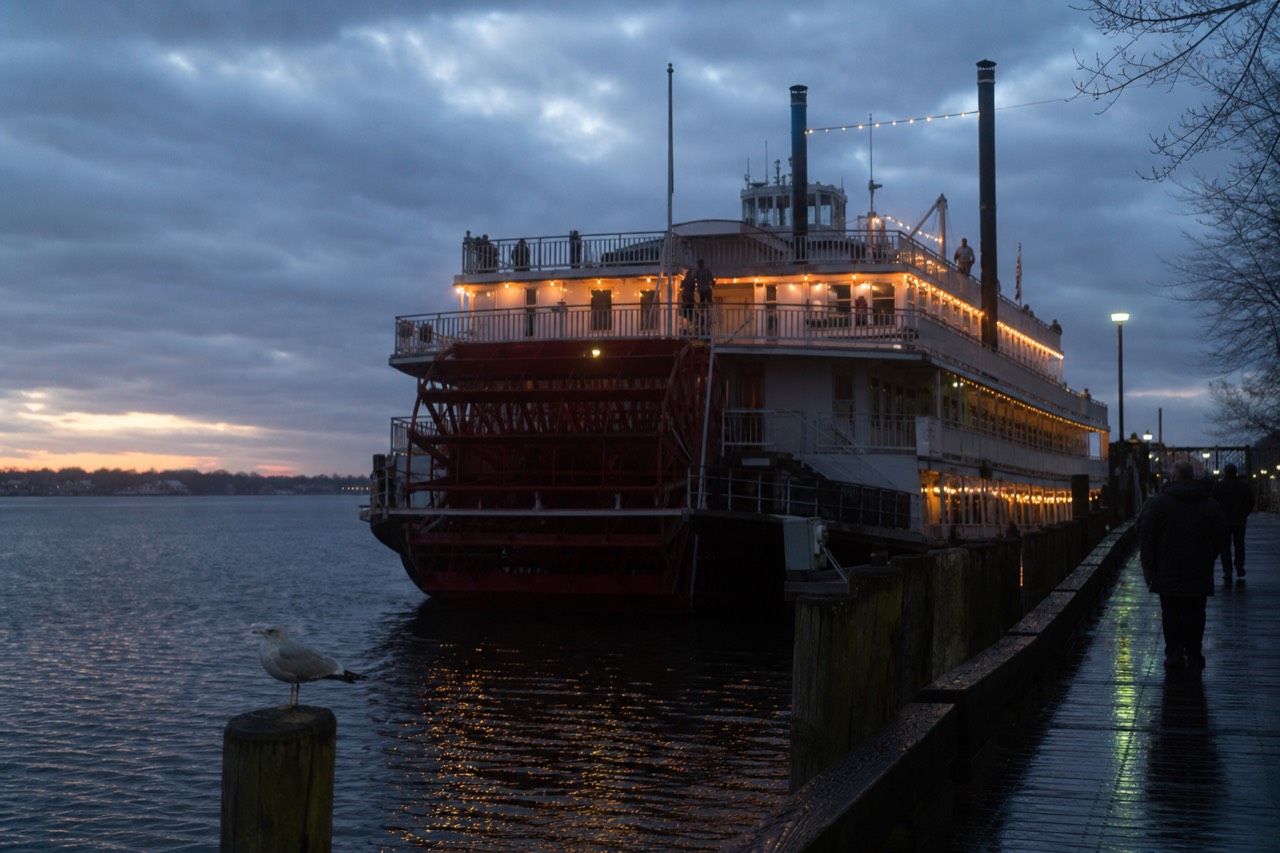 A riverboat lit for the evening docked on the Savannah River at dusk, no text, no logos, no people