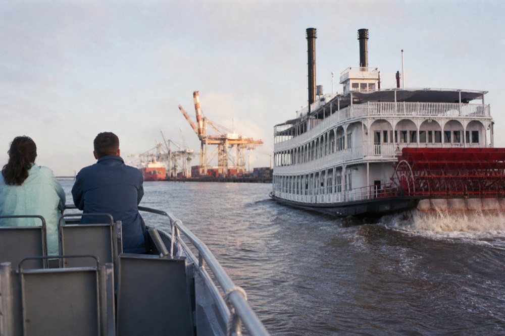 A large paddlewheel riverboat and a small tour boat sharing the Savannah River in late afternoon, no text, no logos, no people