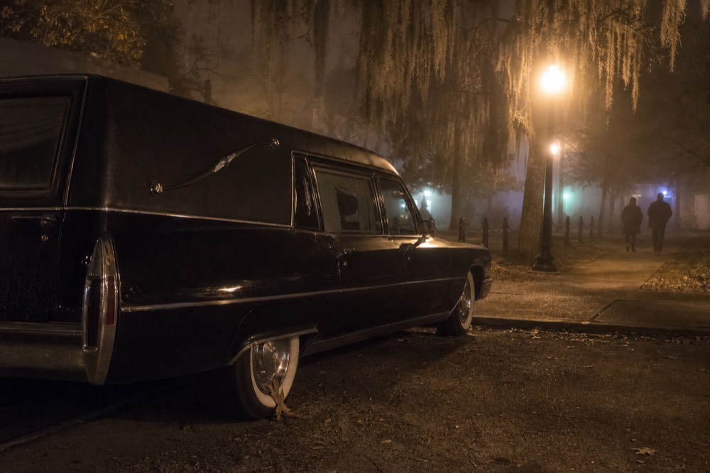 Historic hearse vehicle parked on a Savannah street at night, no text, no logos, no people