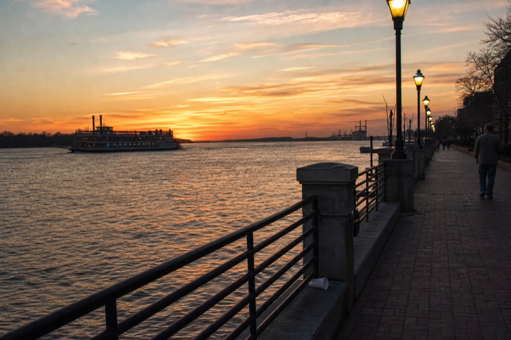 Sunset light over the Savannah River with a riverboat silhouette, no text, no logos, no people
