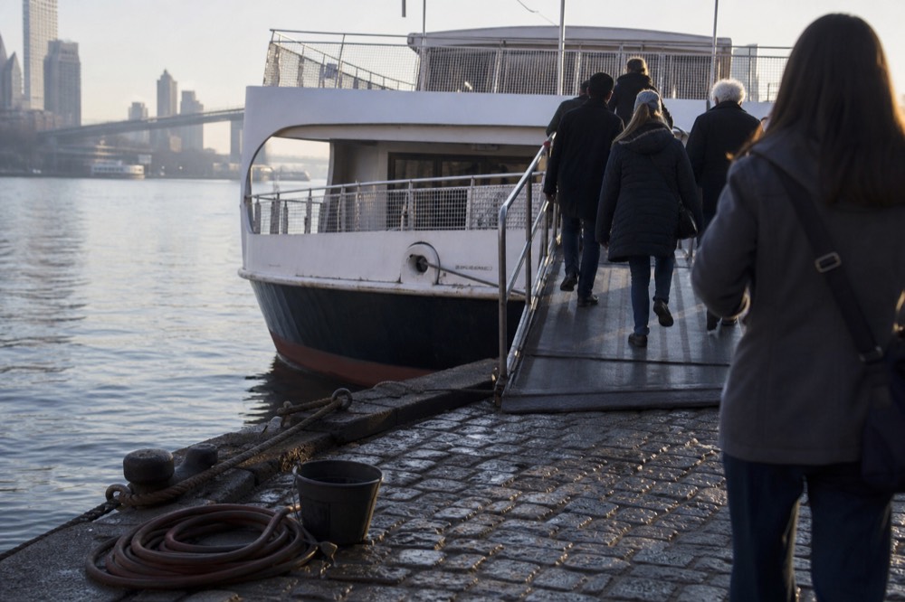 Visitors boarding a riverboat at the East River Street dock in morning light, no text, no logos, no people